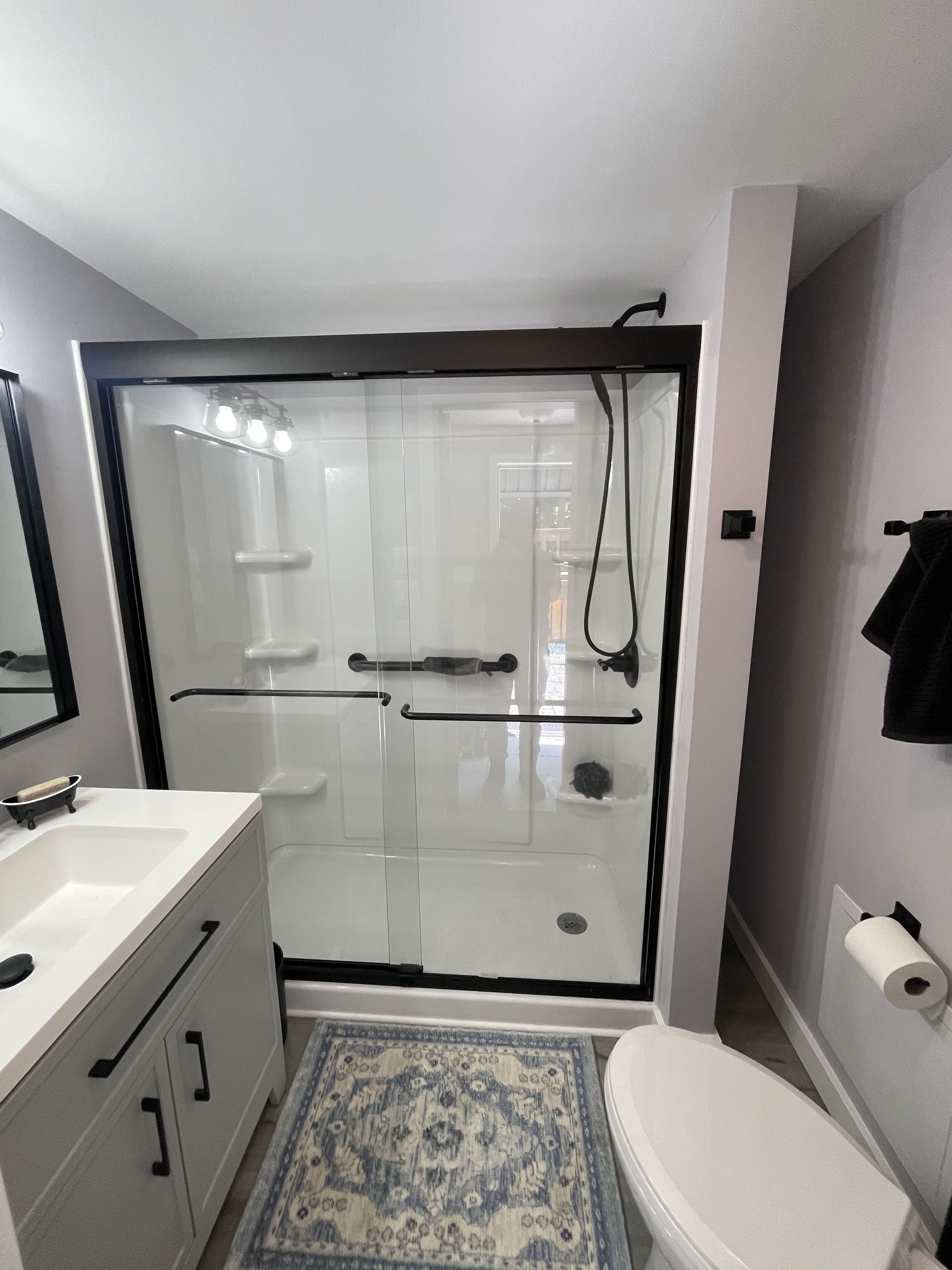 Finished bathroom renovation with updated shower and vanity.